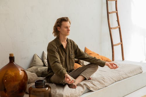 a man meditating on his bed