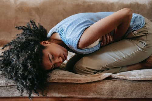 a woman holding her stomach due to unbearable stomach ache