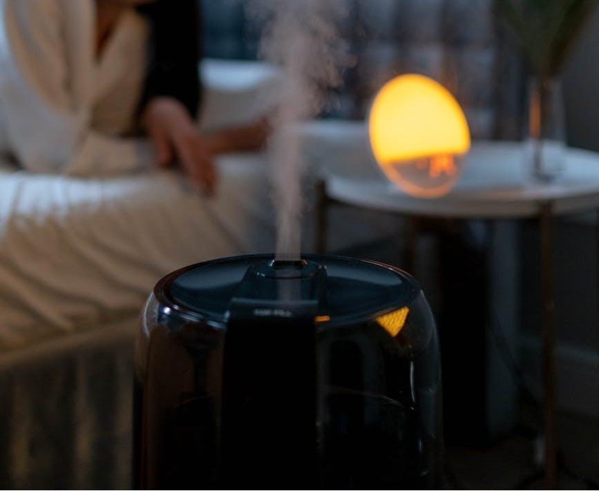 A black humidifier releasing steam. 