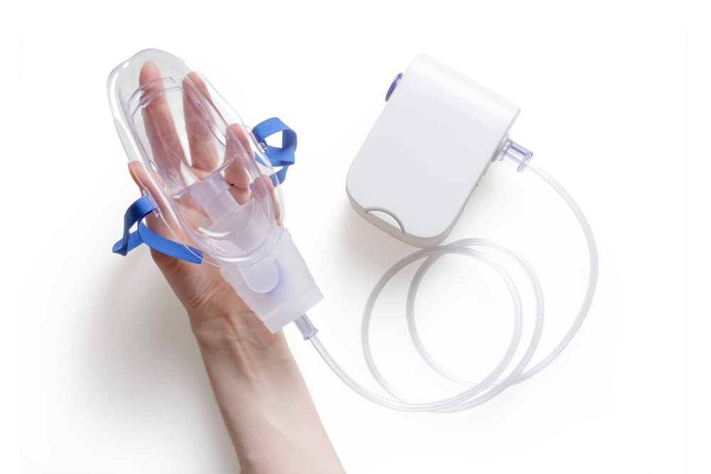 a person holding a white nebulizer