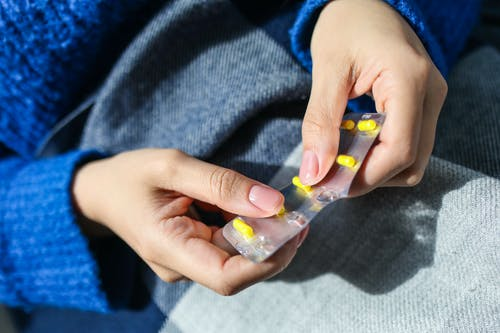 a person holding a blister pack of OTC drugs
