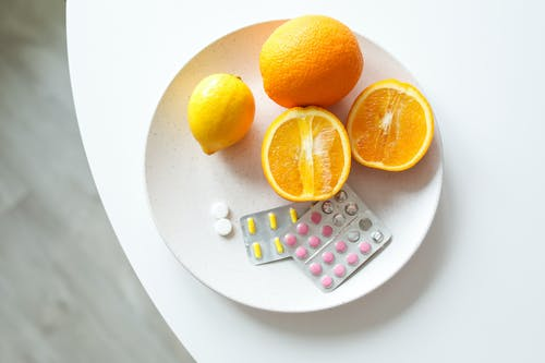 A plate with oranges and affordable dietary supplement products