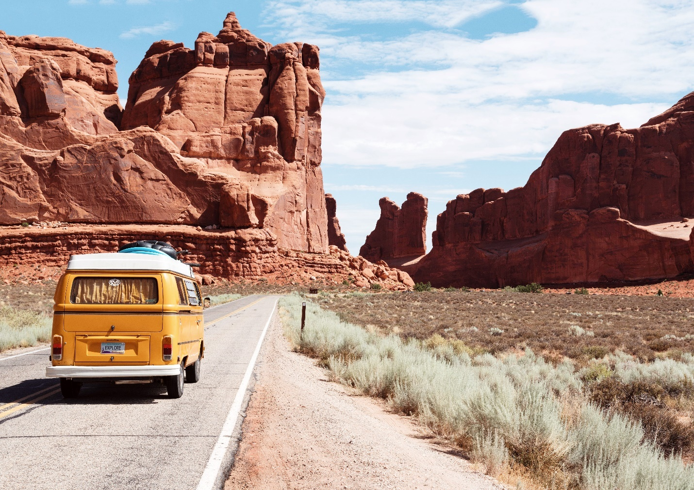 A yellow Volkswagen on a road trip in the desert