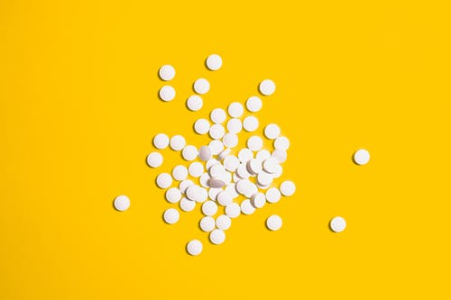 white tablets on yellow surface
