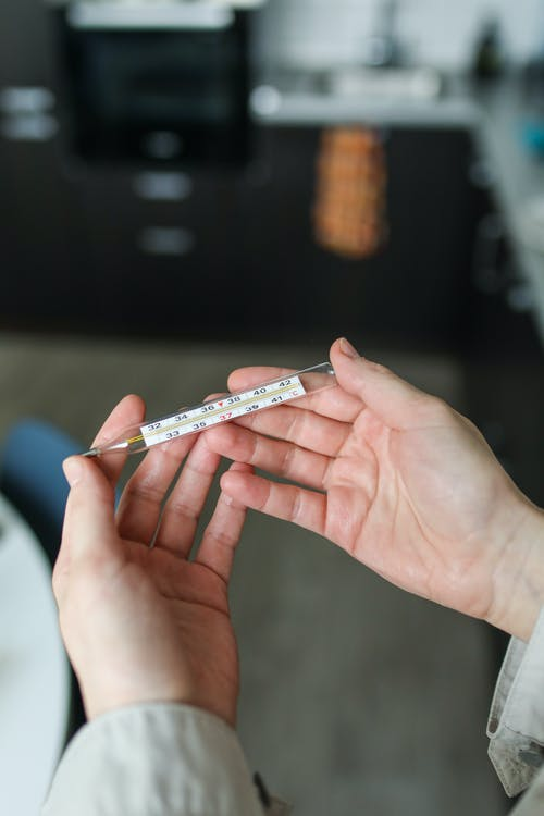 a person holding a white and blue thermometer