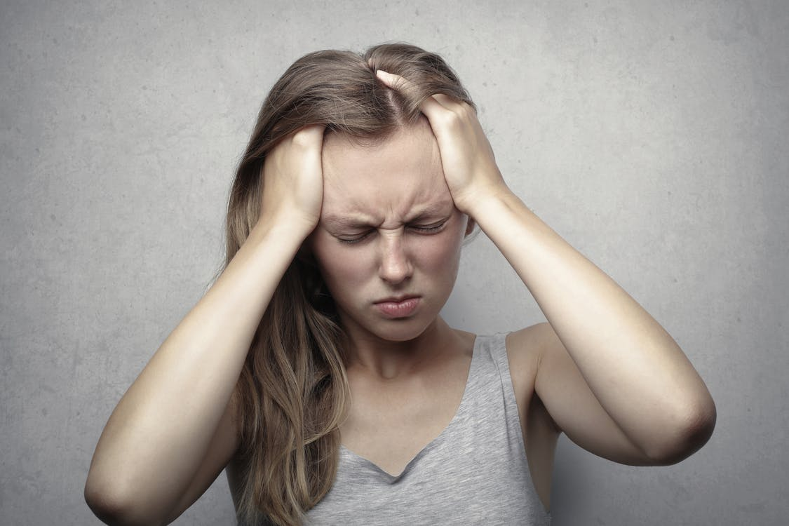  a woman holding her head due to a headache