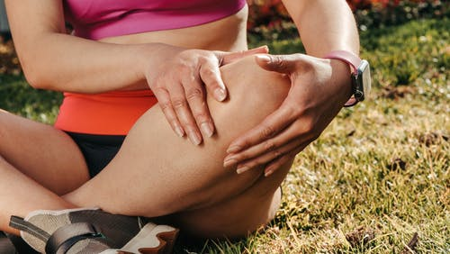 a woman holding her knee due to pain