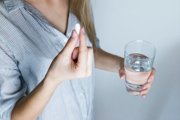 A woman taking pain relief drug for headache