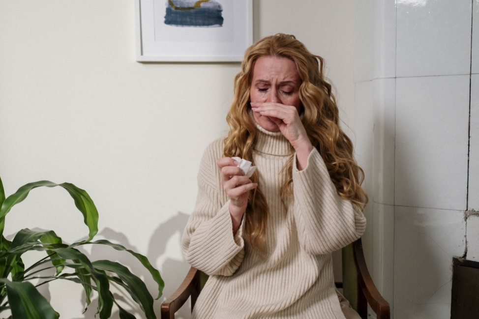 Woman holding a tissue and sniffing